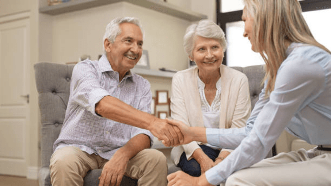 An elderly couple discusses their healthcare and insurance needs with another woman stock image