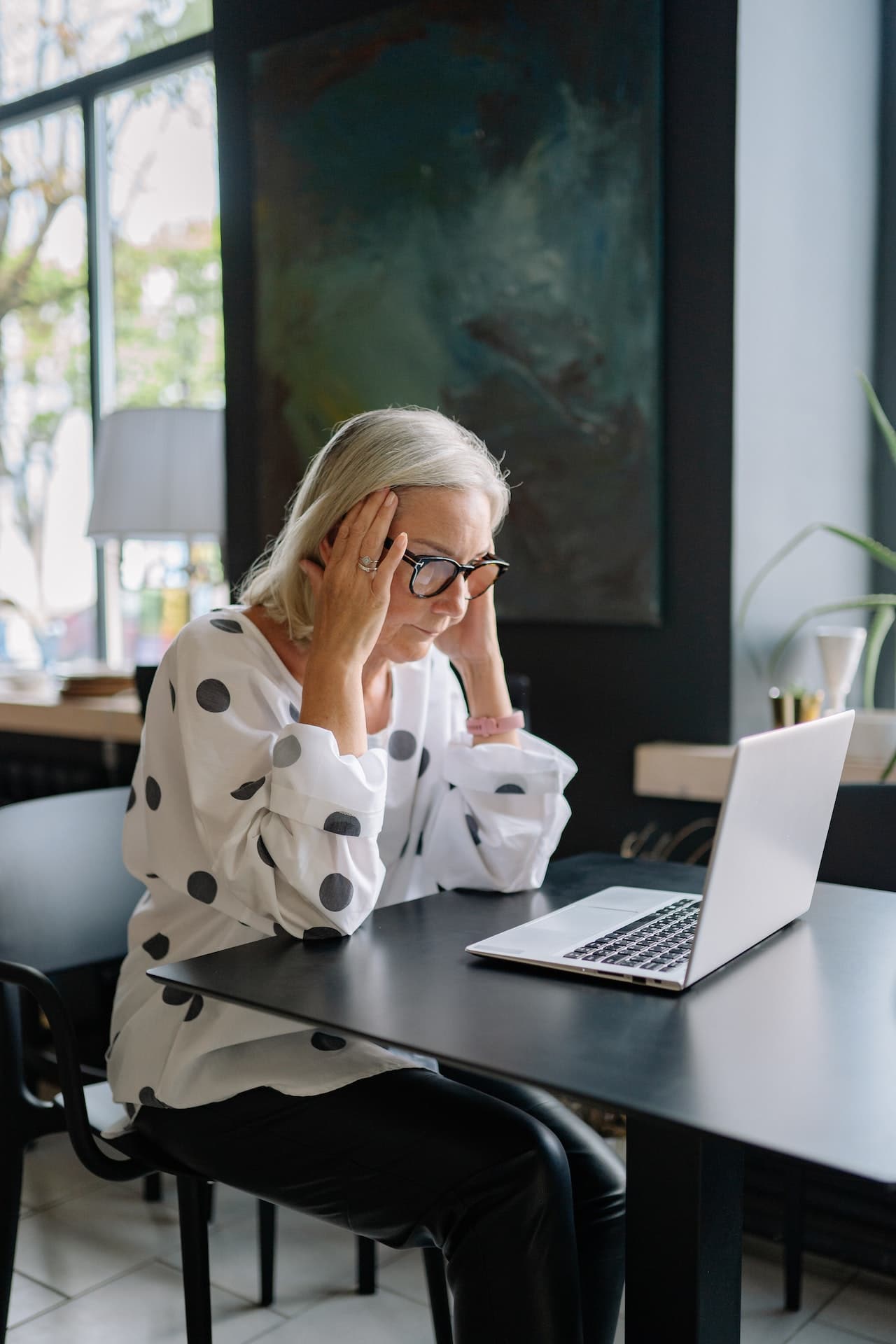 Senior woman fretting in front of her laptop stock photo